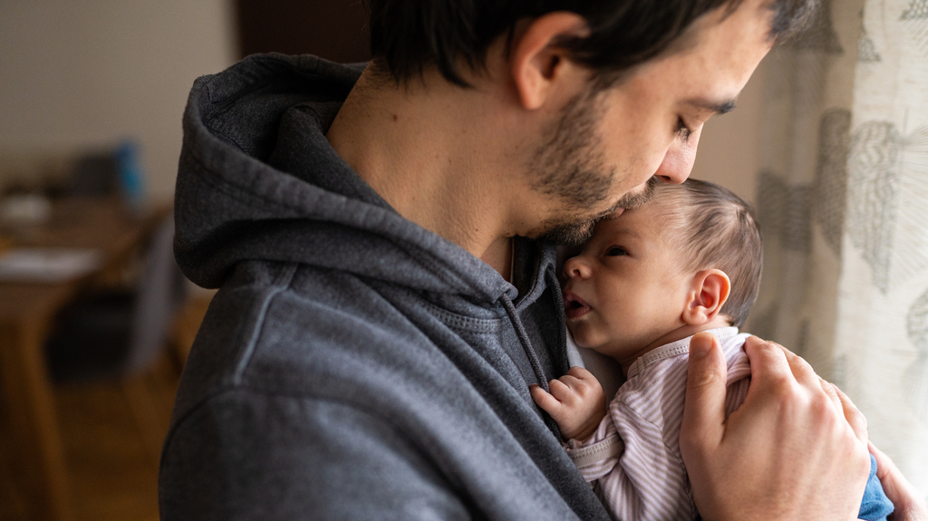 father kissing infant